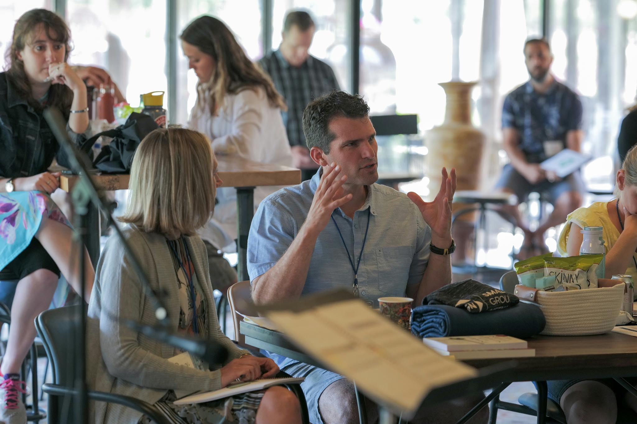 Church leaders and members gathered around tables in conversation